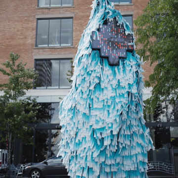 A sculpture made of plastic that makes it look almost fuzzy. There is a screen on the sculpture showing pixelated characters.